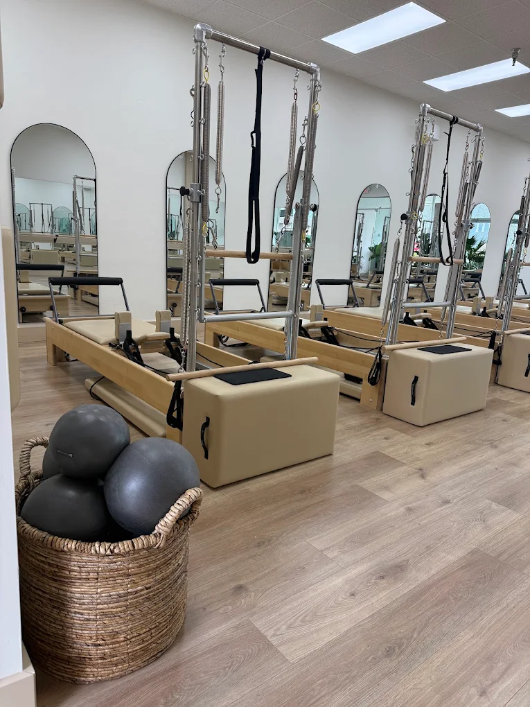 Client working on a Pilates reformer in a warm neutral studio